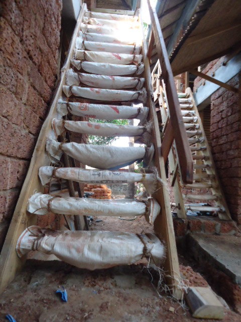 A hut under construction on-site, laterite block and timber frame — the same hands-on building practice behind PCF's construction prototypes and its own retreat